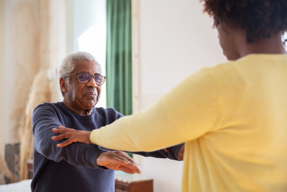 forest cottage senior care - An elderly man with a caregiver assisting him in exercise at home.