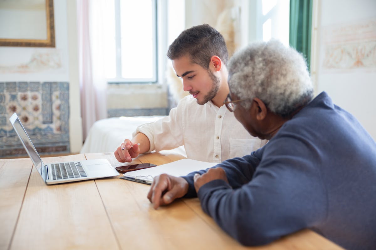 Caregiver smiling and talking with elderly person