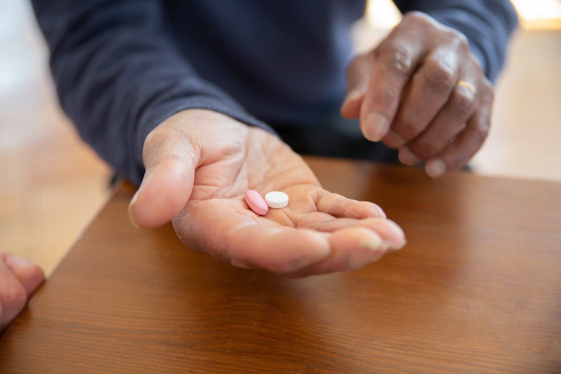 Person Holding White Medication Pill