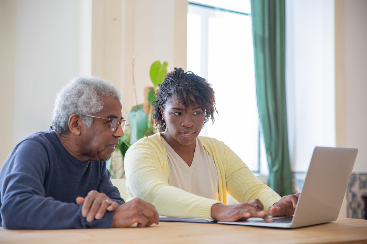 An adult child supports an older parent during a calm moment at home