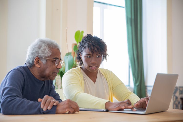 A Man And A Woman Using A Laptop Together