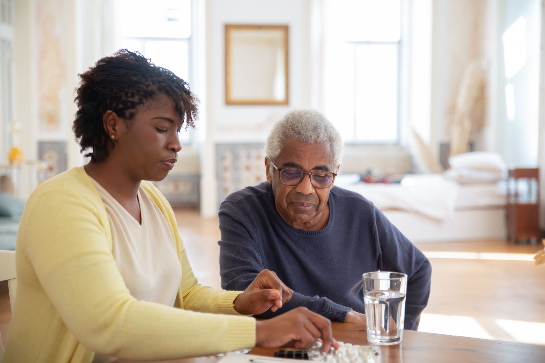 A home-care nurse reviewing medication with an older adult patient