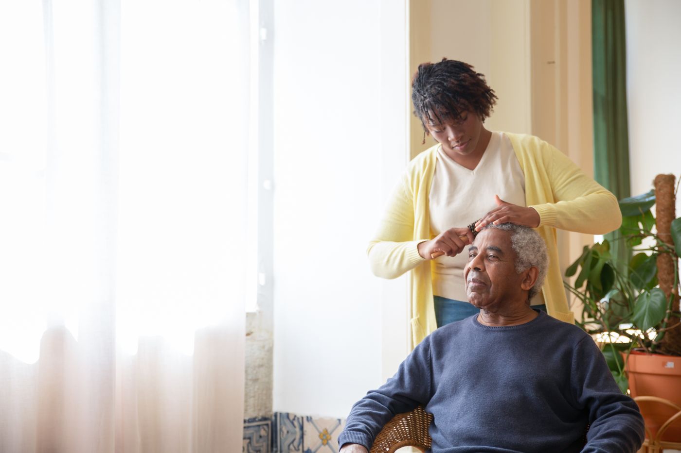 Caregiver helping a client with grooming at home