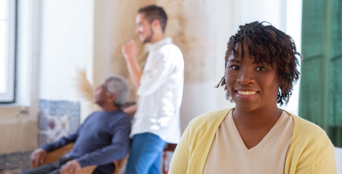 A caregiver warmly welcoming a resident into a bright apartment