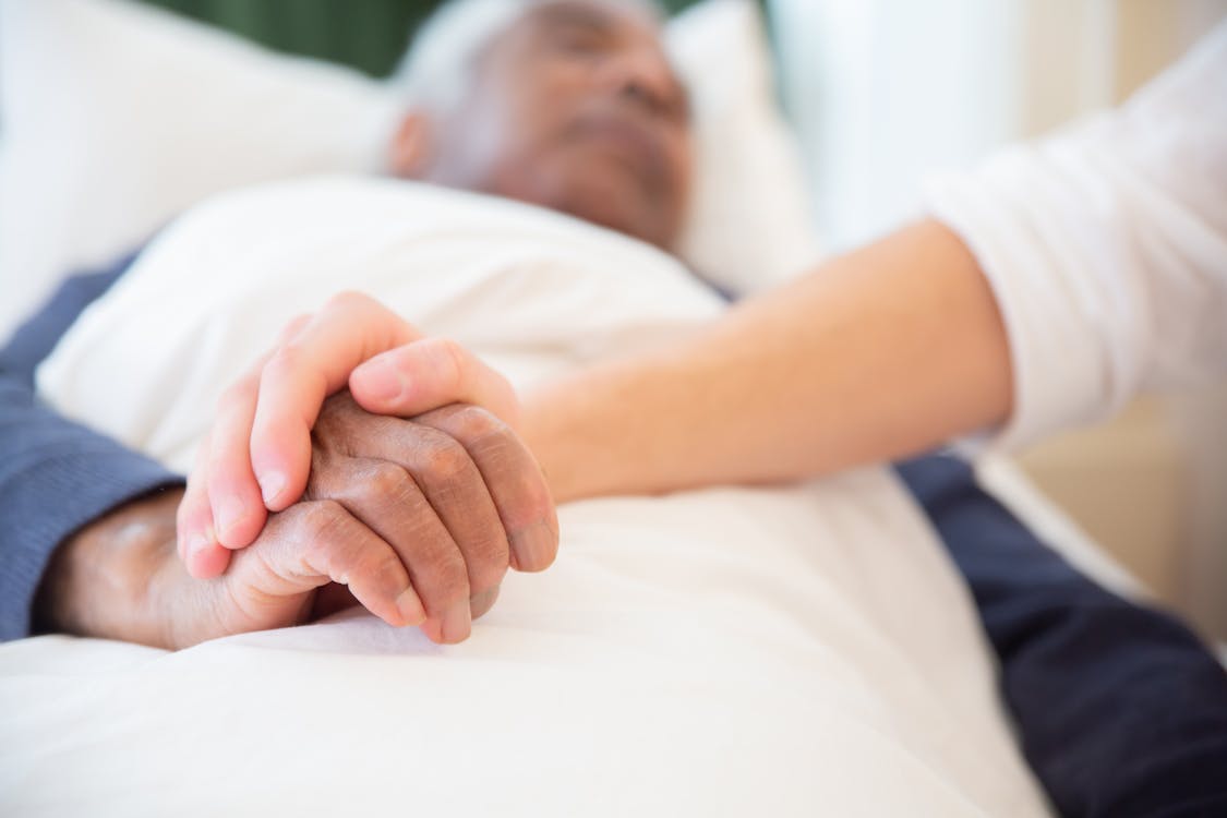 Free Young Persons Hand Holding an Old Persons Hand Stock Photo