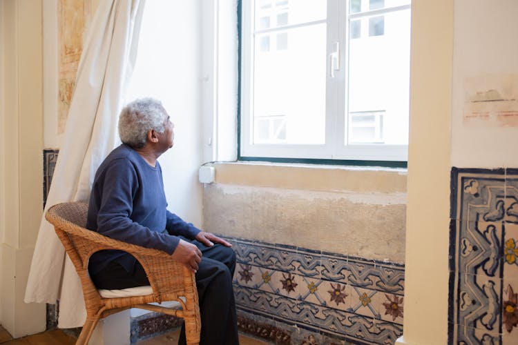 Photo Of An Elderly Man Sitting Near A Window