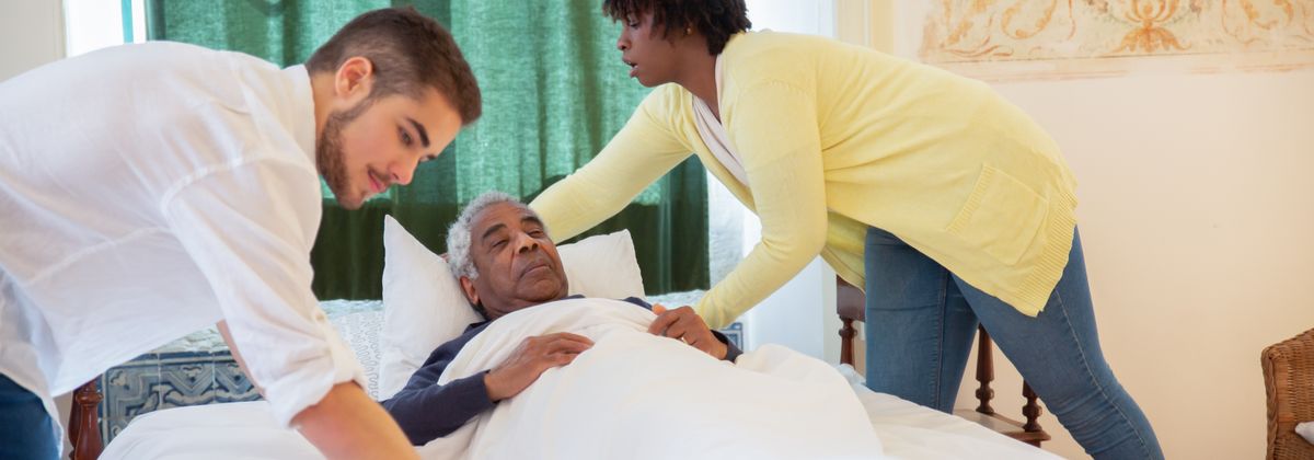 Caregivers helping an older adult at home