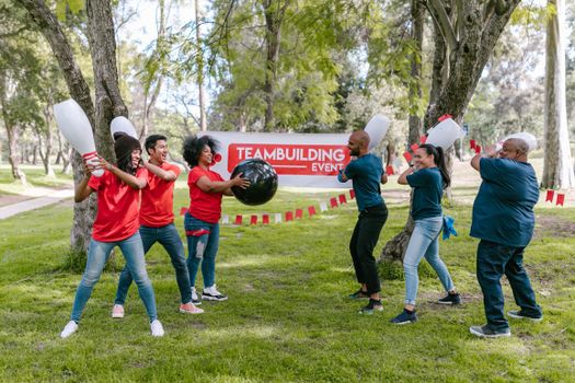Dynamic outdoor team building activity with diverse group playing in the park.