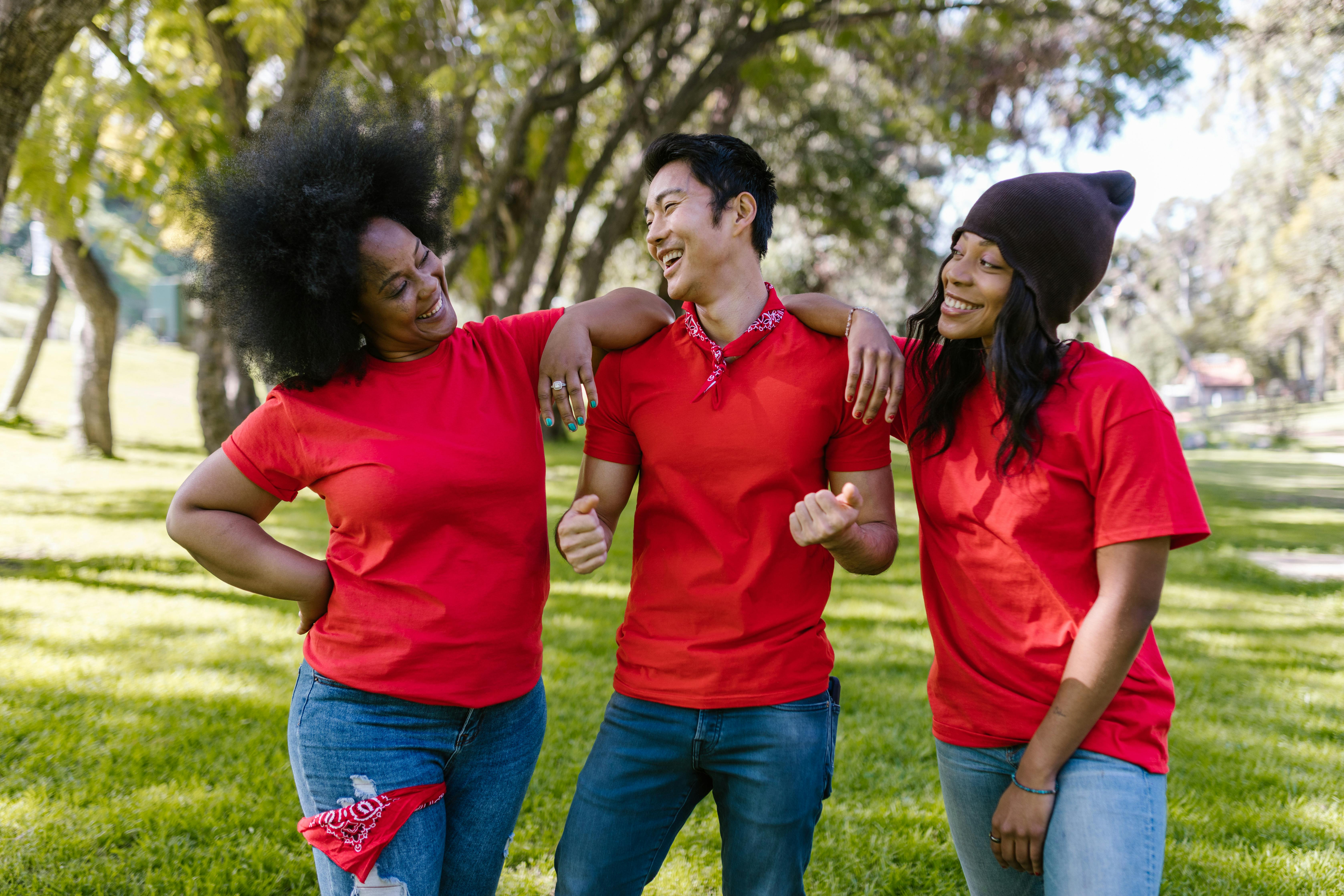 A diverse group of friends laughing and bonding outdoors in the park.