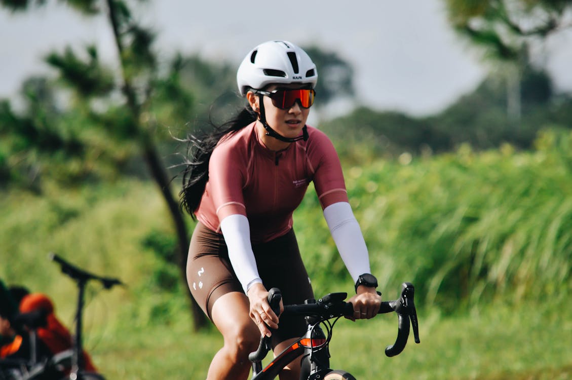 A Woman Wearing White Helmet Cycling
