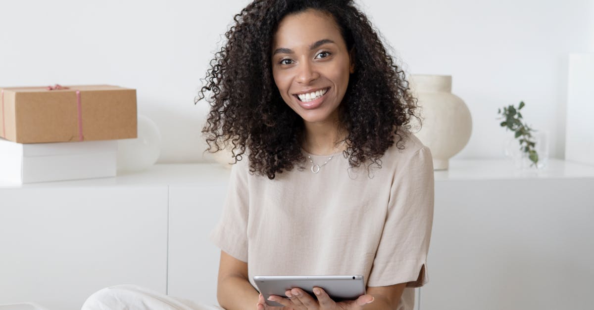 Photo by Hanna Pad A confident young woman sitting among packages and papers while using a tablet, showcasing modern entrepreneurship.