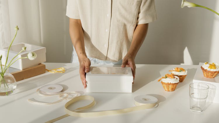 A Person Holding A White Box