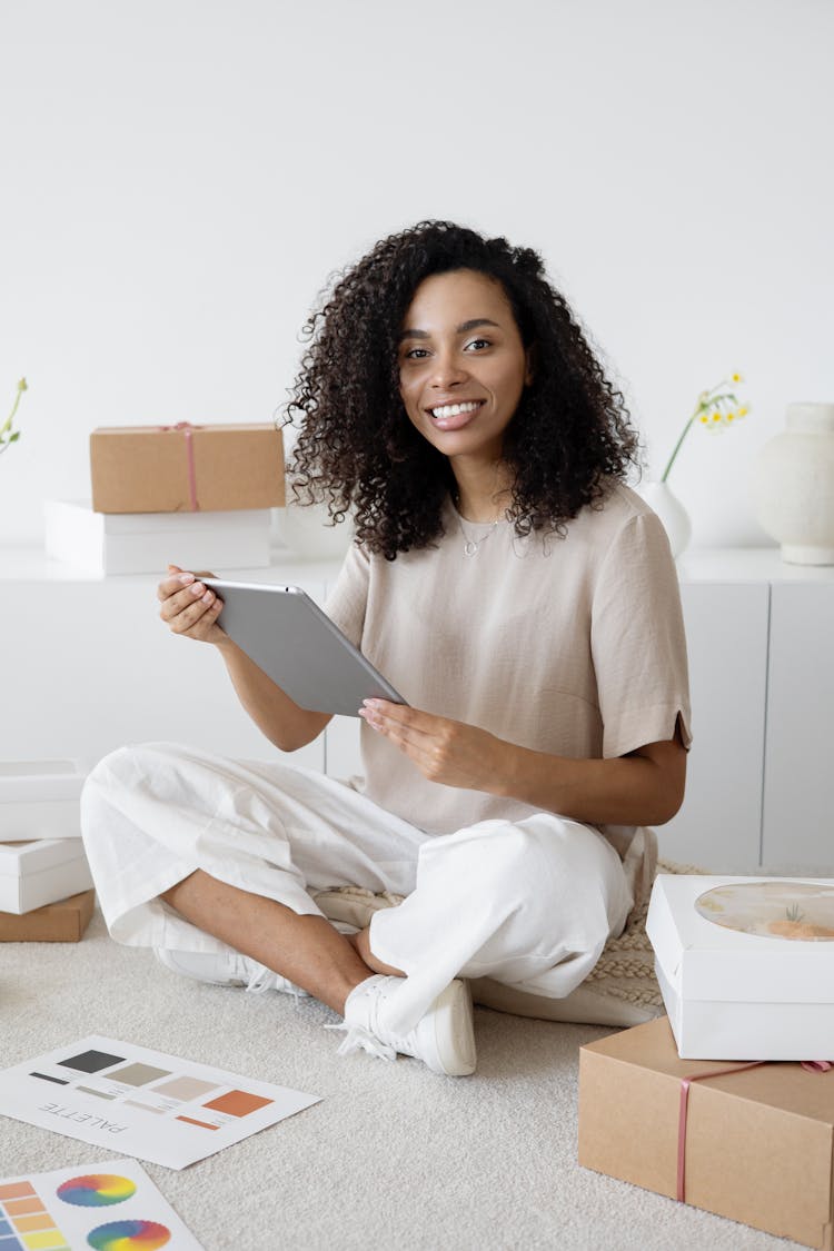 Photograph Of A Woman Smiling While Holding Her Tablet