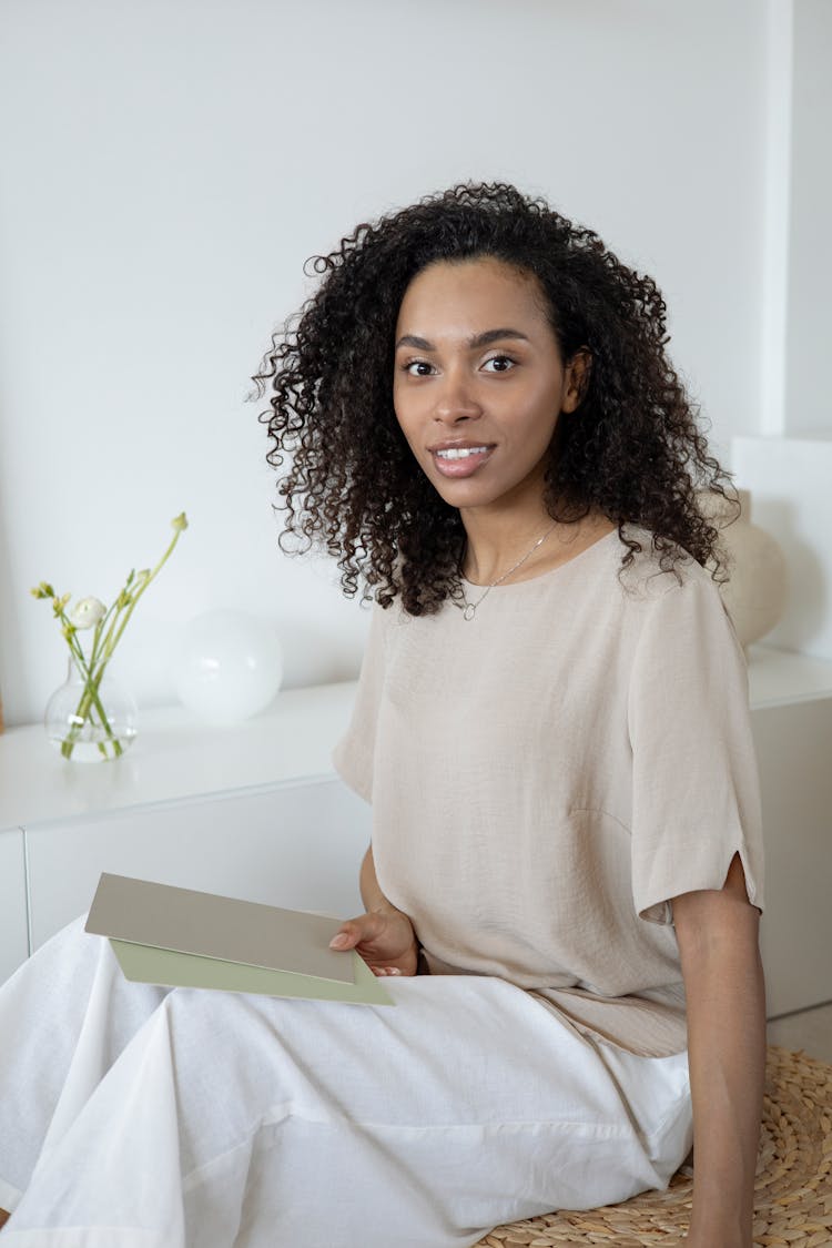 A Woman With Curly Hair Holding Cards