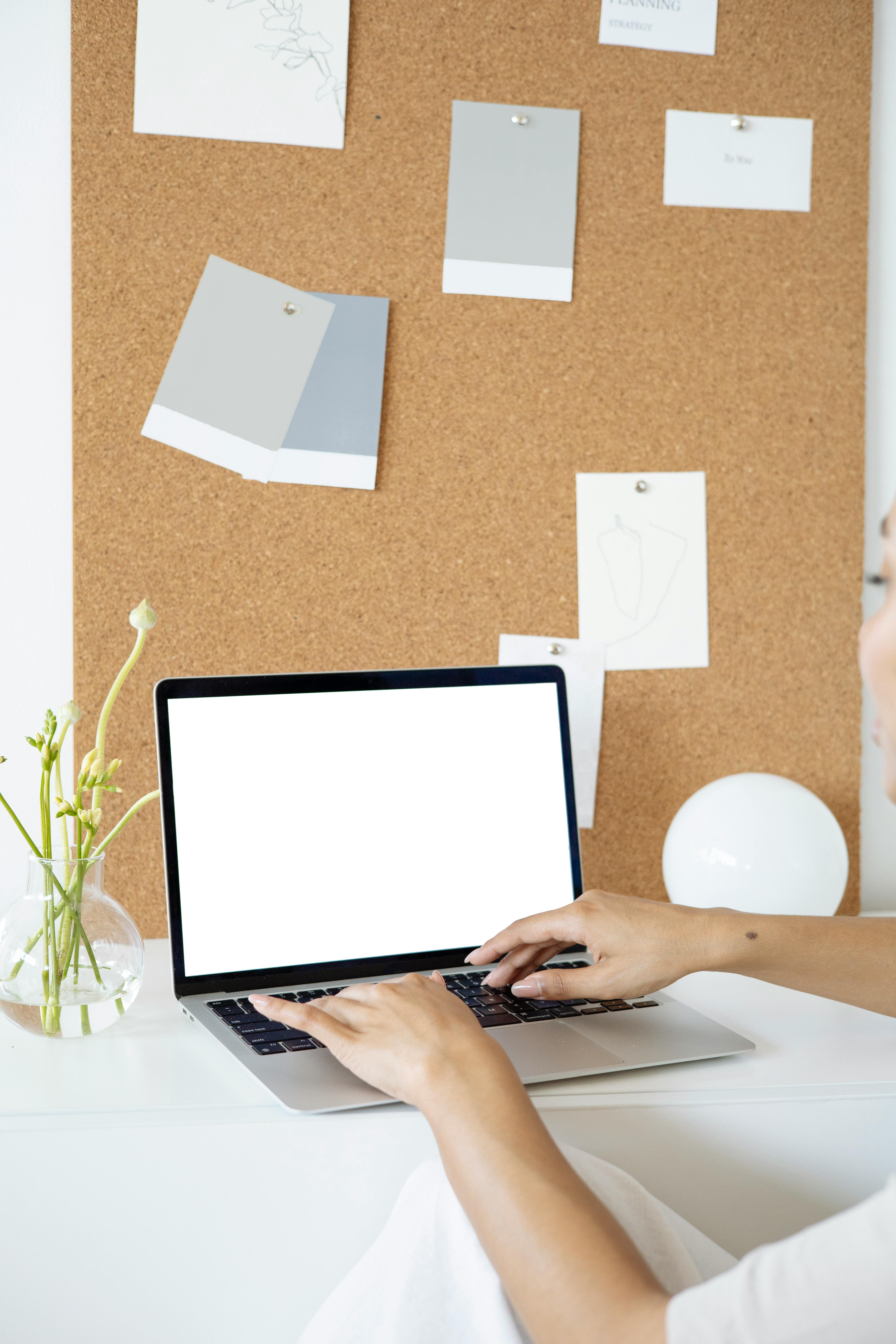 person using a laptop on white table