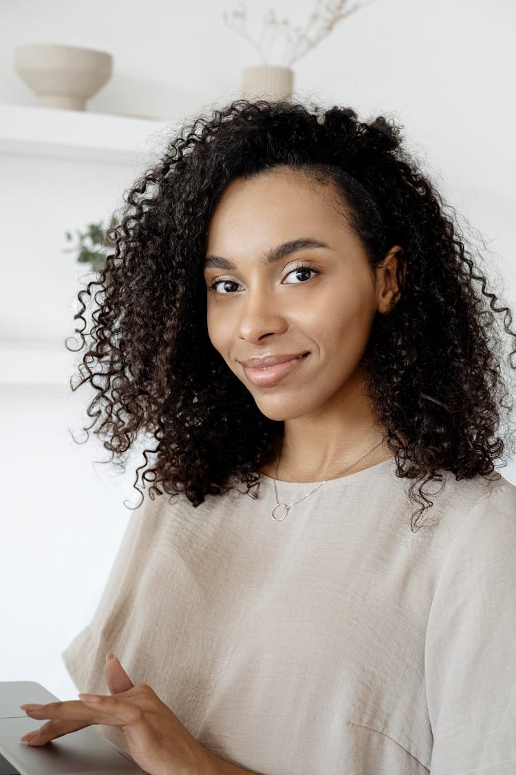 A Woman With Black Curly Hair Smiling