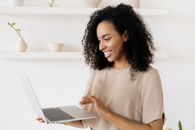 A woman reading information on her laptop at home