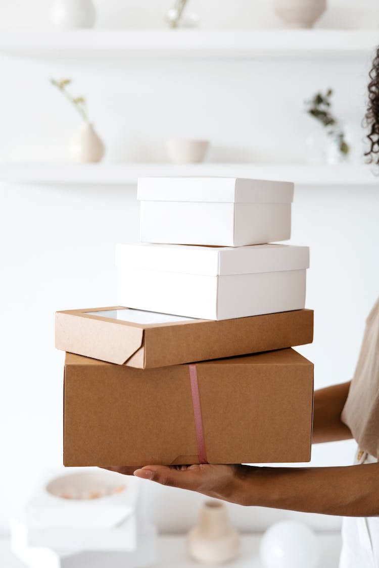 Close-Up Shot Of A Person Holding A Stack Of Boxes