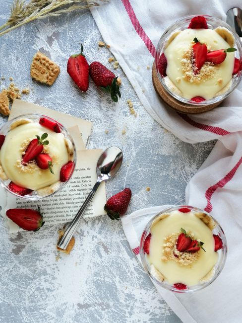 Delicious strawberry and cream dessert presented in glass cups with a high-angle shot.