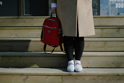 Person Standing on the Stairs with a Backpack