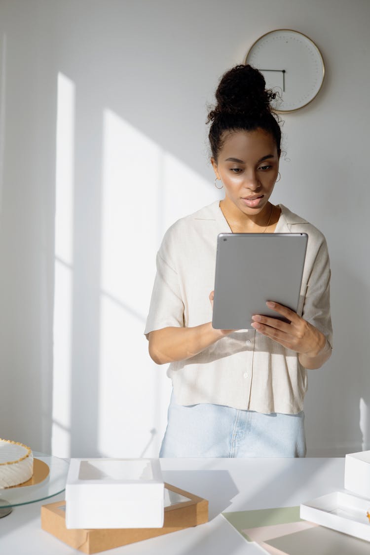 Woman In White Shirt Using A Silver IPad