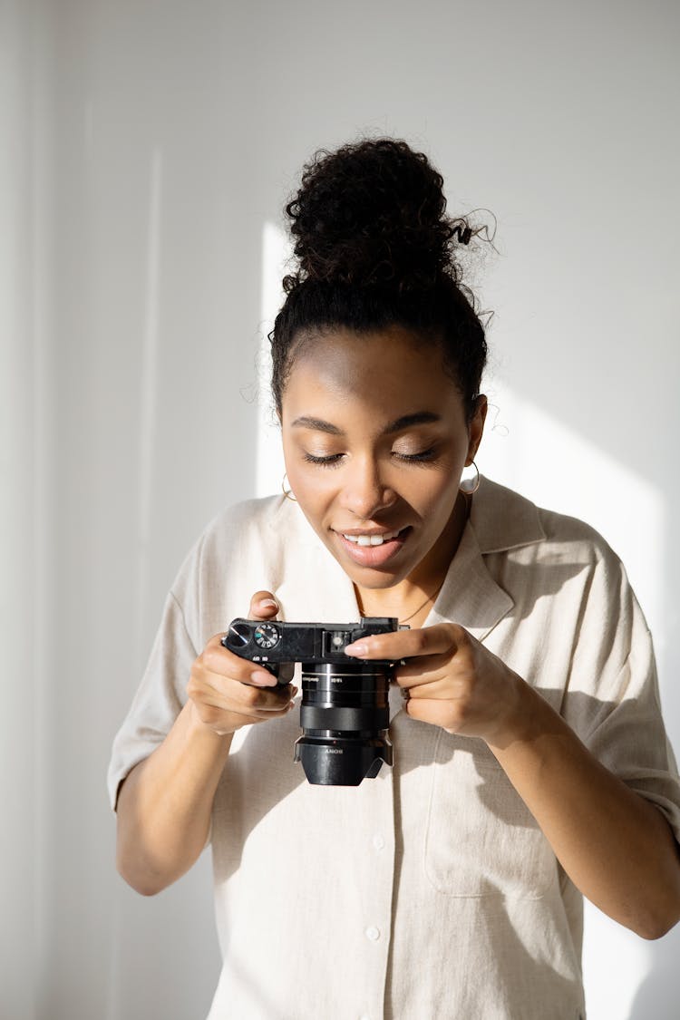 A Woman Using A Black Camera