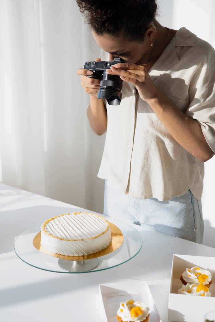 A Woman Taking A Picture Of A Cake