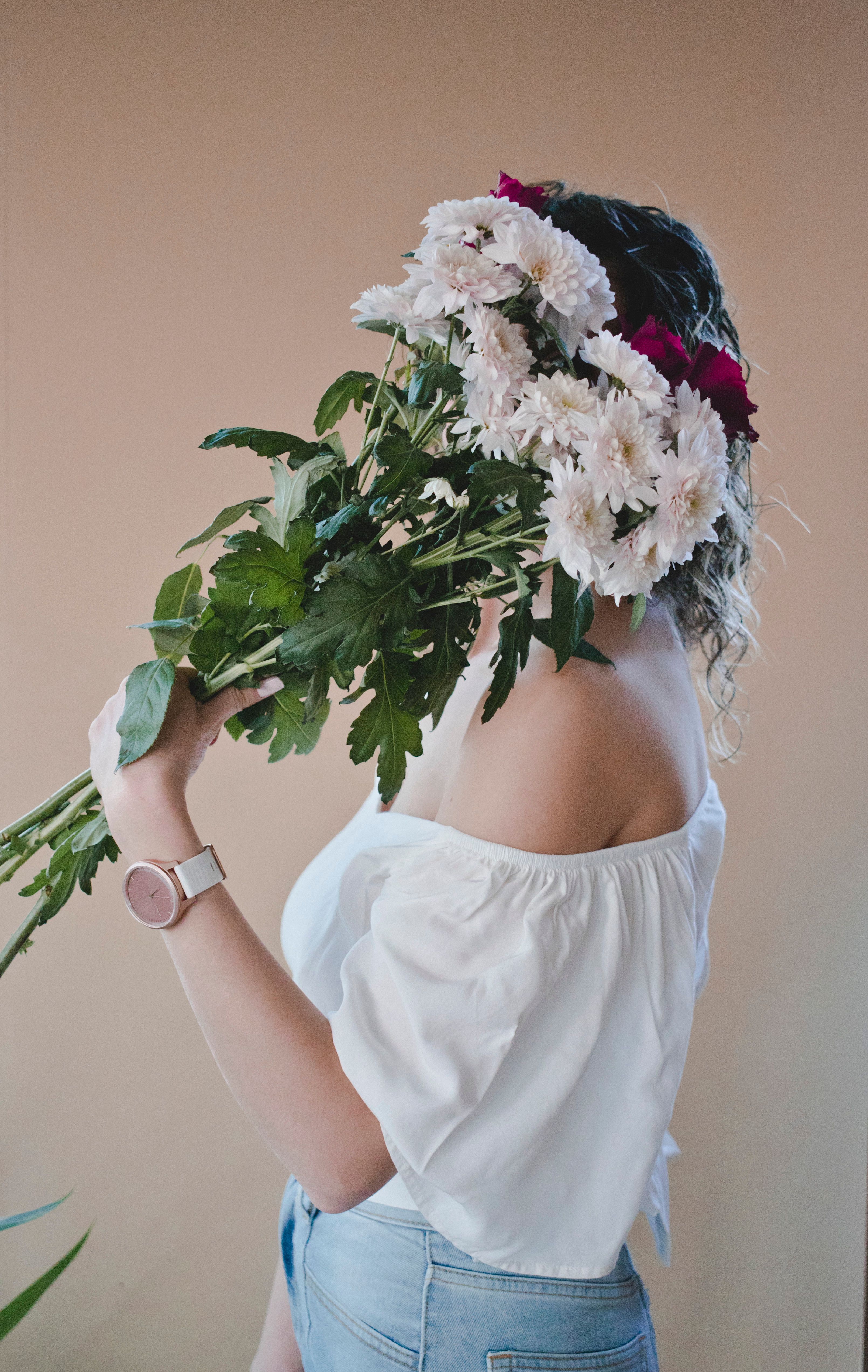 Photo of a Woman Holding White Flowers · Free Stock Photo
