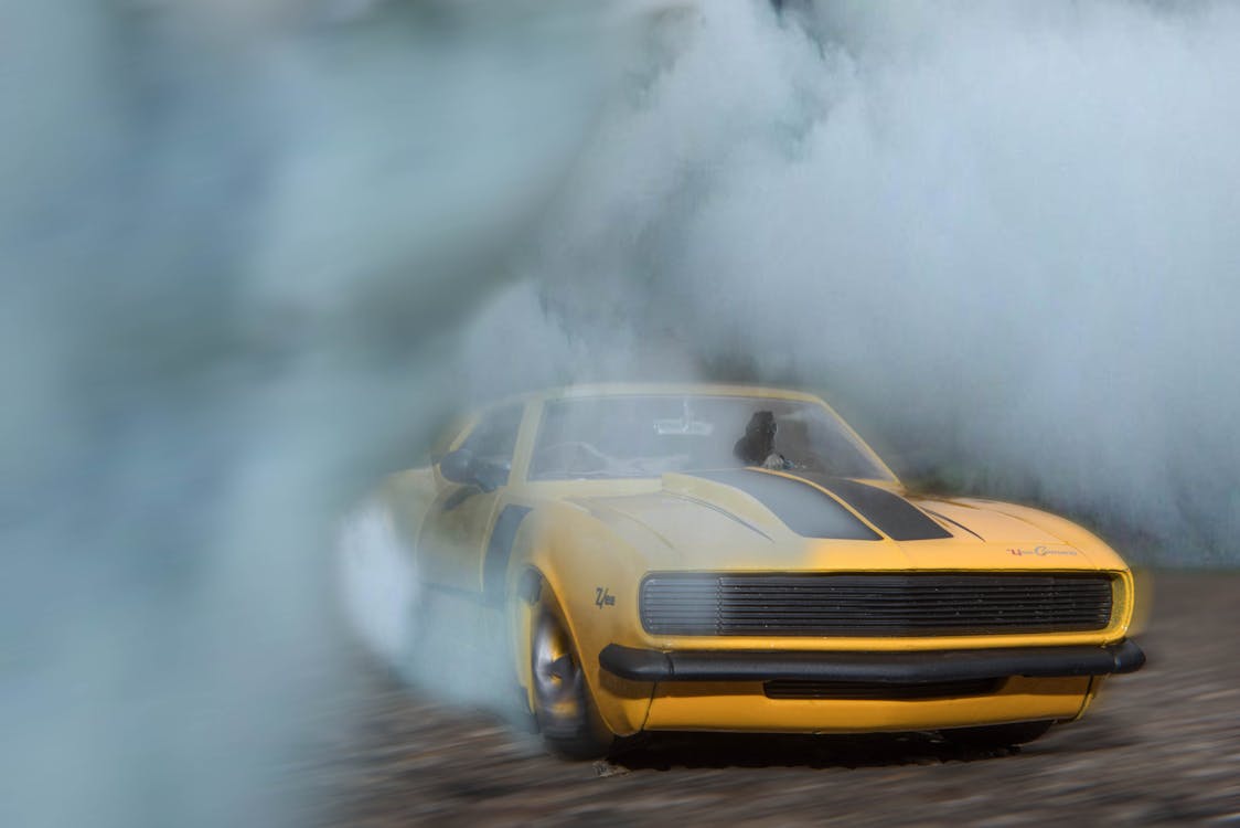Free Classic Yellow And Black Sports Car Drifting On Road With Smoke Stock Photo
