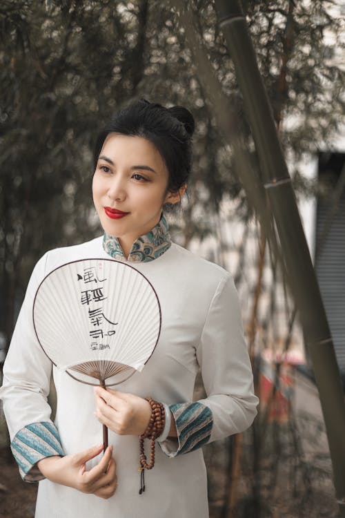 Beautiful Woman in a White Traditional Clothing Holding a Hand Fan