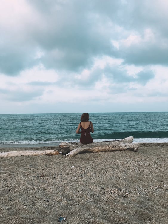 Unrecognizable woman sitting on beach