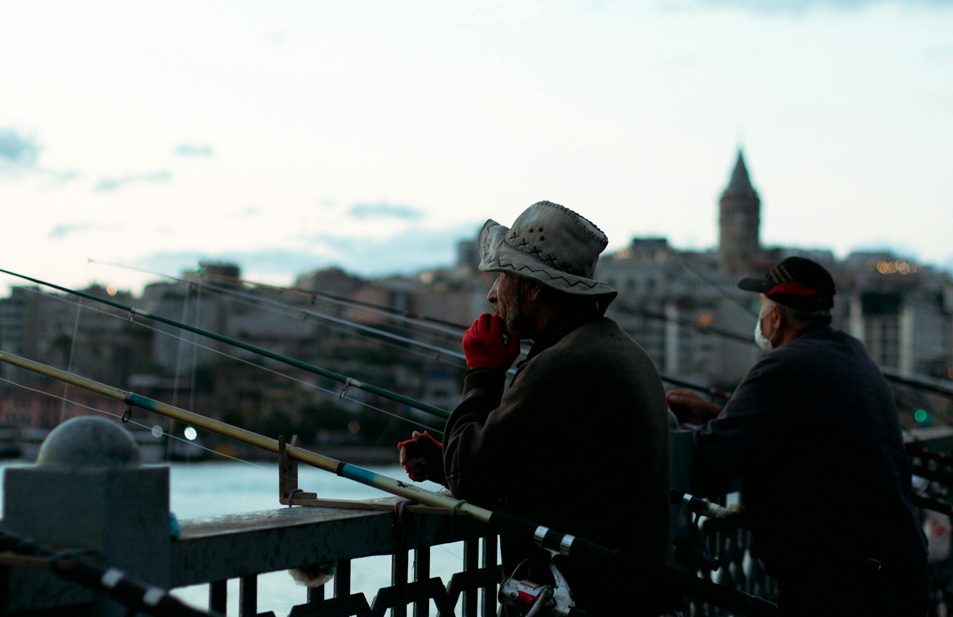 Fishermen standing on waterside in city