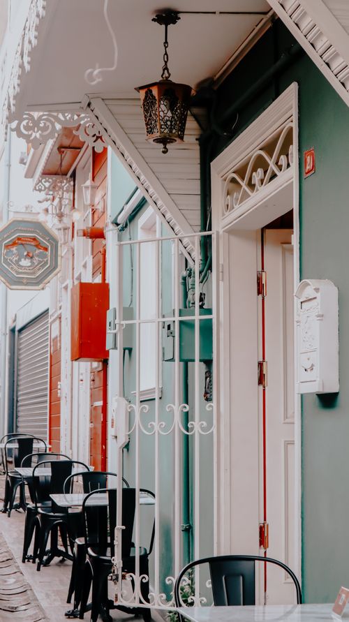 Free A quaint outdoor café with colorful facades and wrought iron details, perfect for street exploration. Stock Photo