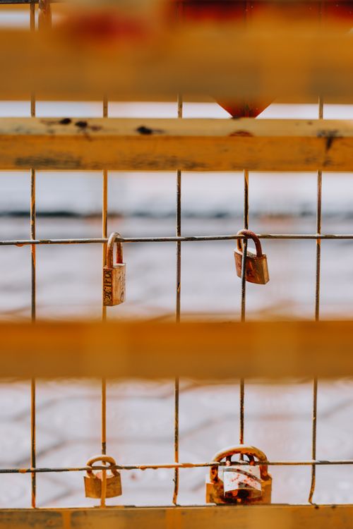 Free Close-up of love padlocks attached to a bridge fence, symbolizing romance and commitment. Stock Photo