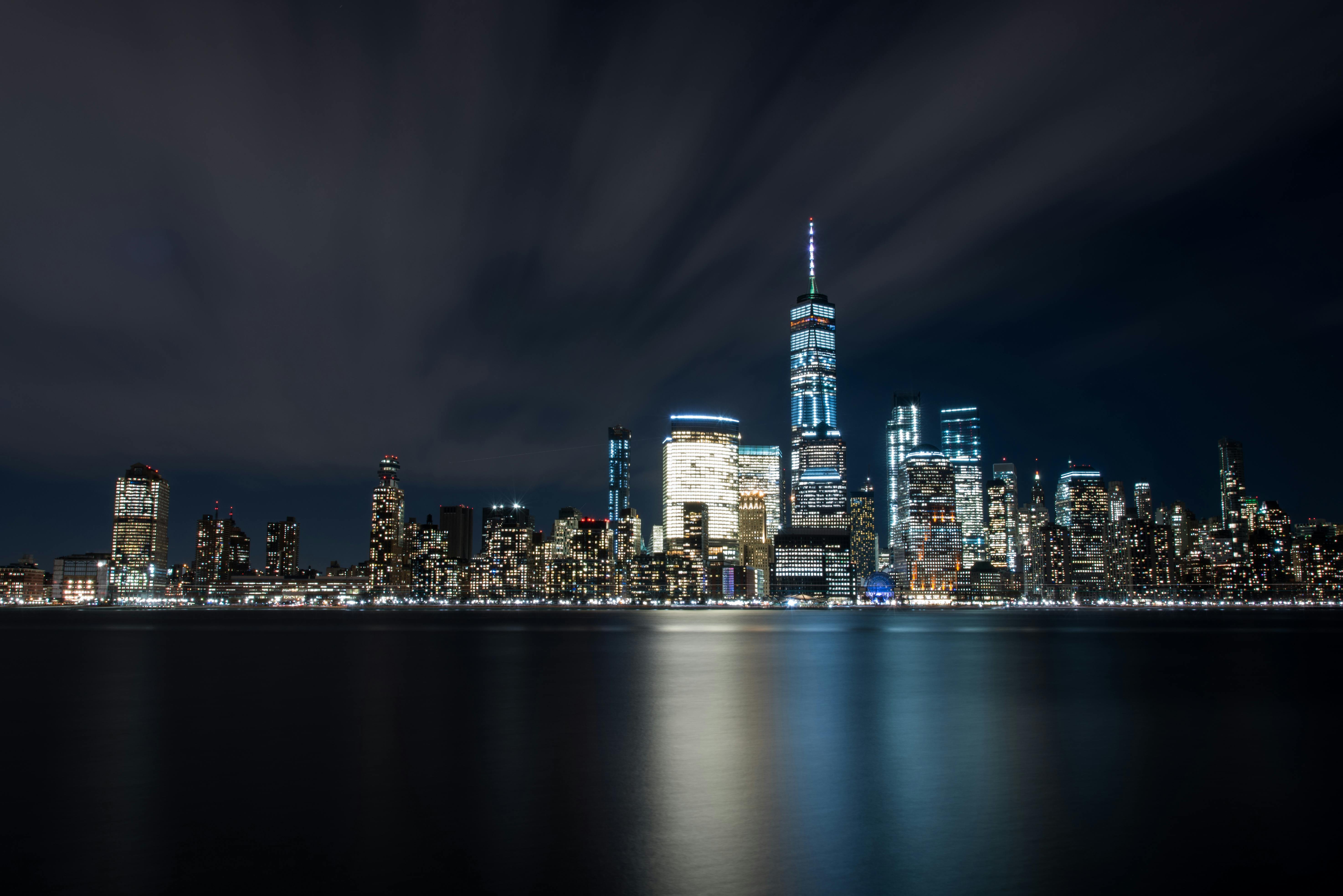 high rise buildings at night near sea