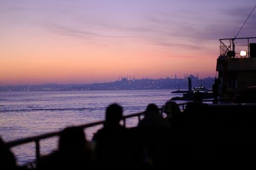 deniz, gün batımı, insanlar içeren Ücretsiz stok fotoğraf