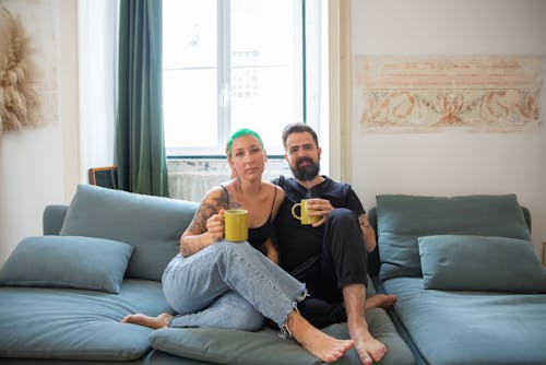 Free Couple Sitting on a Blue Couch Stock Photo