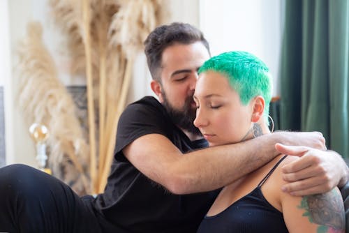 A Man in Black Shirt Kissing Woman in Black Tank Top