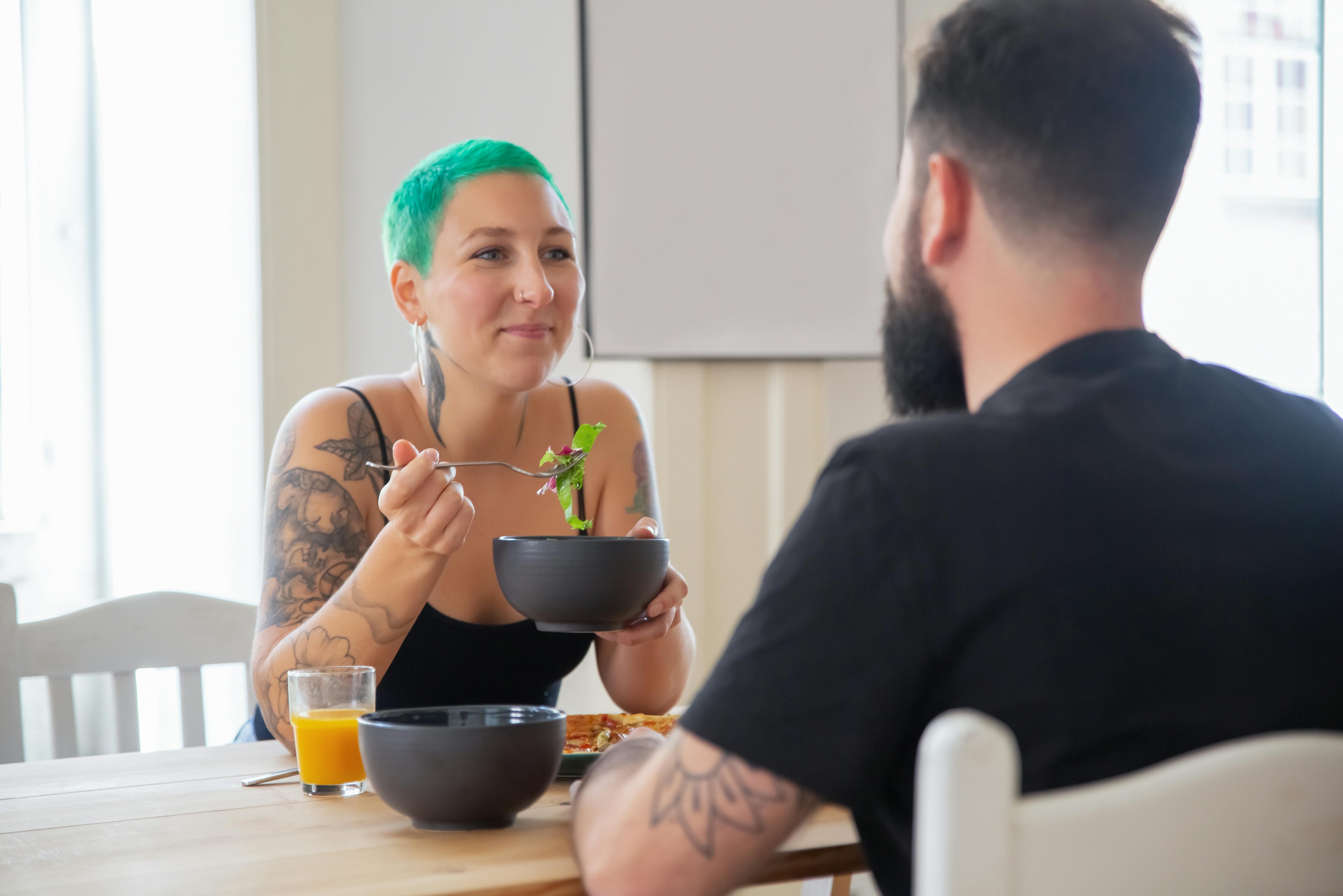 A couple enjoying a healthy breakfast together indoors, smiling and relaxed.