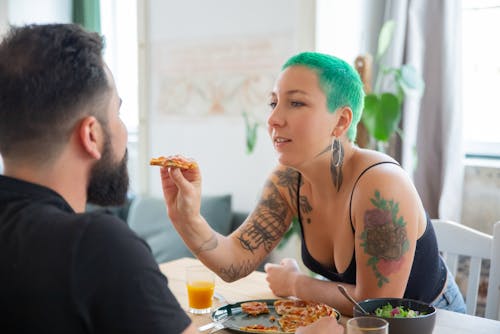 Free A Woman Giving Pizza to a Man Stock Photo