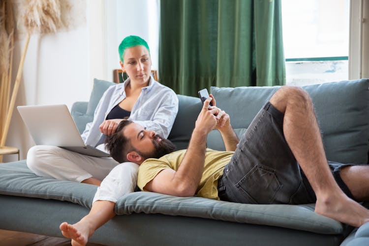 A Man Lying On The Woman Lap On The Sofa 