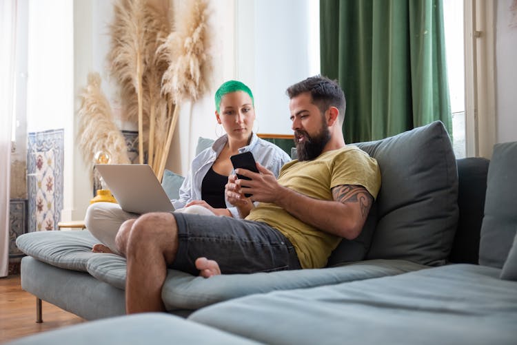 A Man And Woman Sitting On The Sofa 