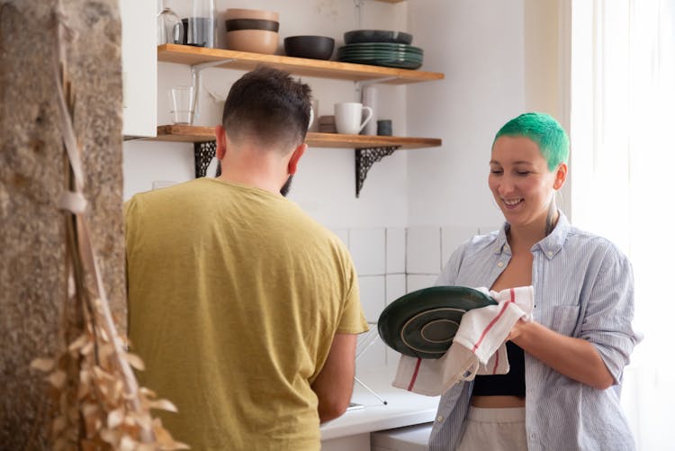 Couple Washing Dishes In Kitchen