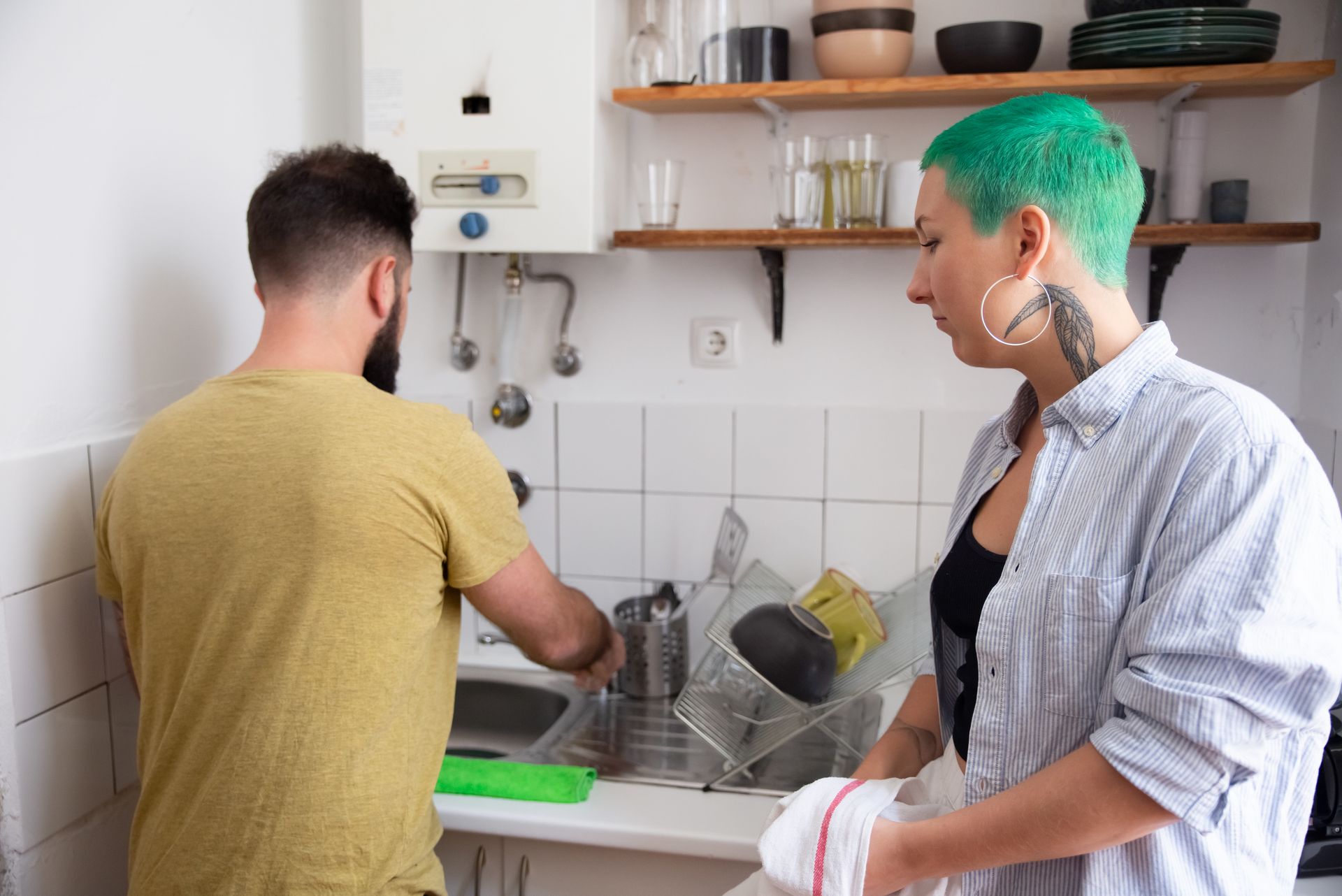 A modern couple sharing household chores in a stylish kitchen, highlighting teamwork and daily routine.