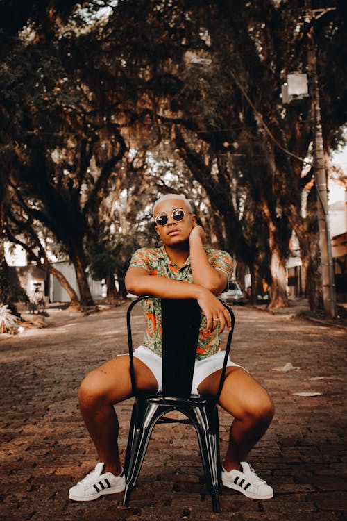 Stylish black man in sunglasses sitting on chair