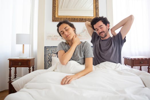A couple comfortably waking up and stretching in an elegant bedroom setting.