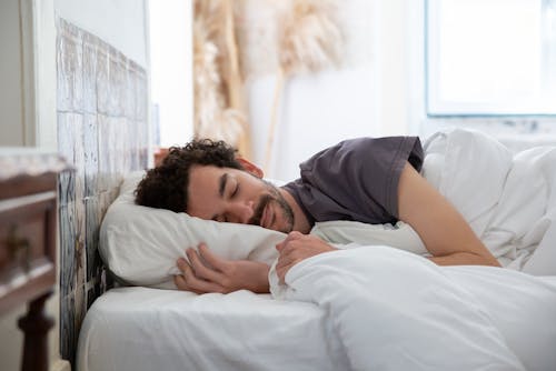 Free Man sleeping comfortably in Bed Stock Photo