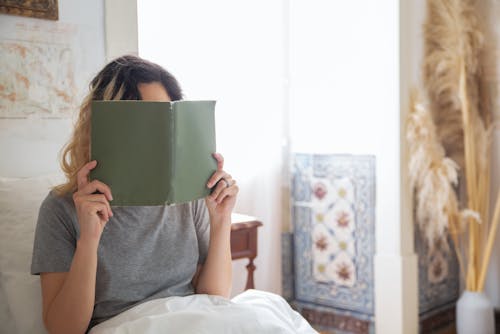 Free Woman in Gray Shirt Reading a Book Stock Photo
