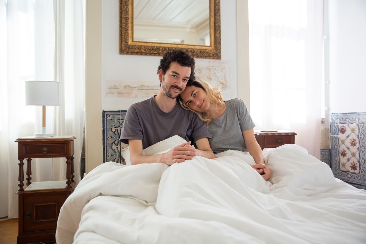 A relaxed, happy couple enjoying a slow morning in bed
