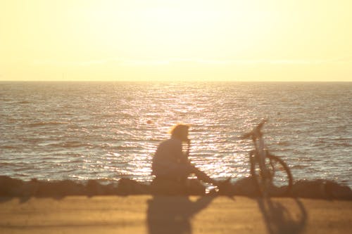 Man with Bicycle on Sea Shore